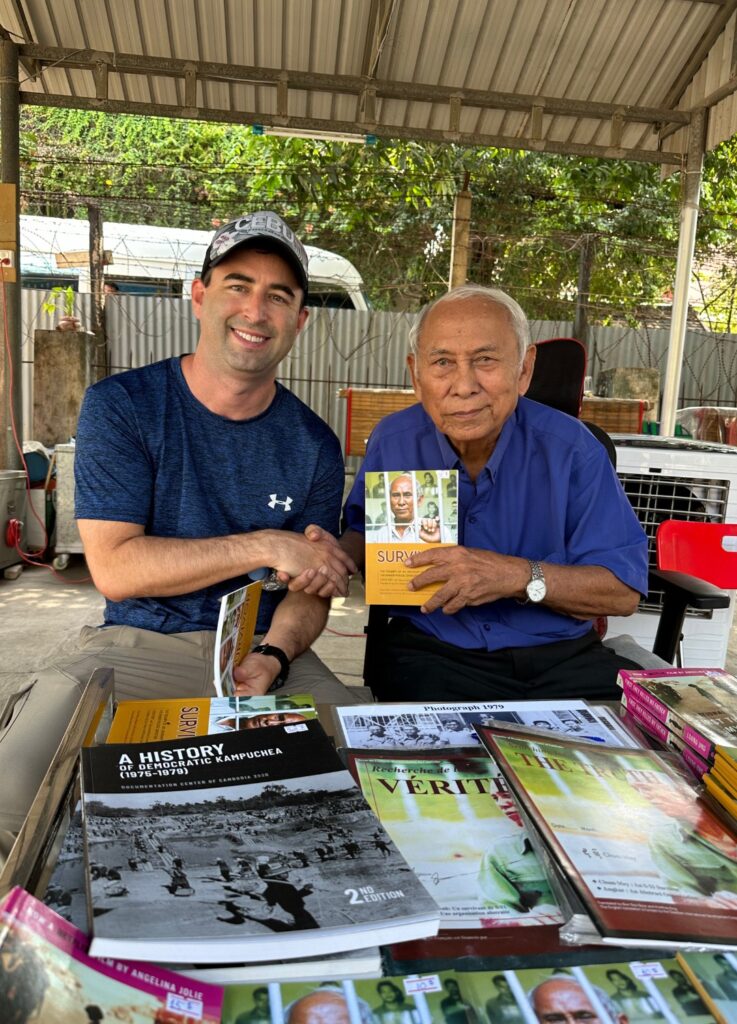 American tourist with Chum Mey, a Pol Pot regime survivor at the killing fields.