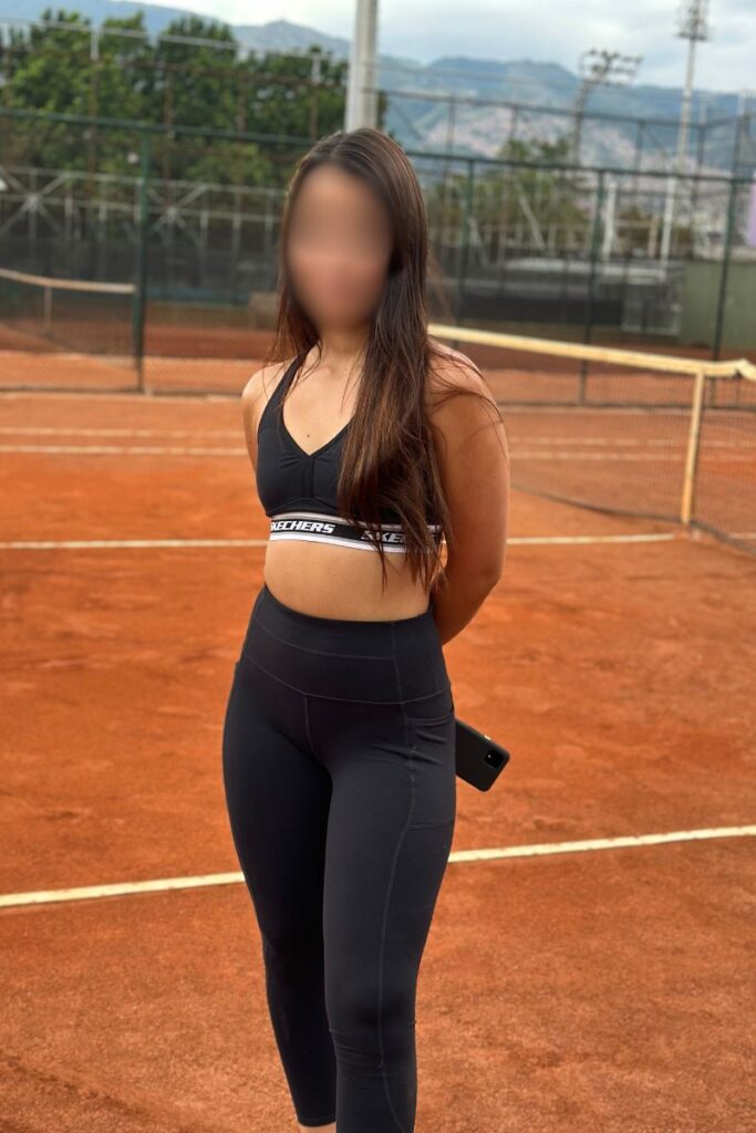 Attractive Colombian woman standing on tennis court in Medellin, Colombia at Estadio tennis courts at Atanasio Girardot Stadium.