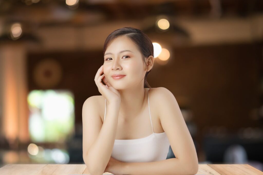 Beautiful Thai woman sitting in a cafe at a table.