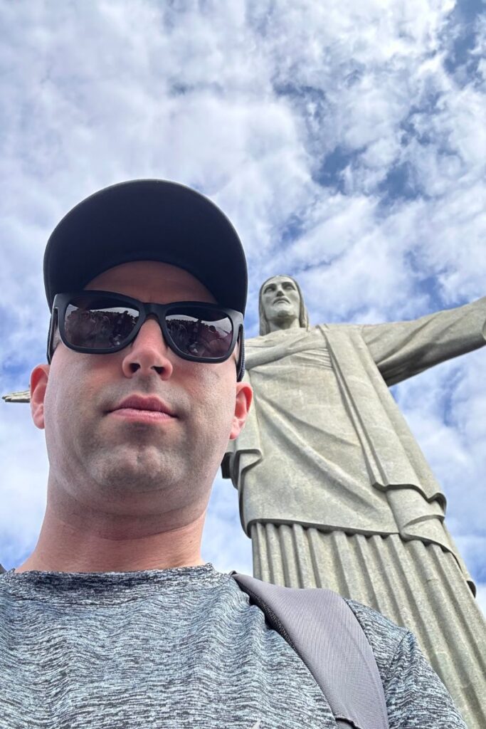 Eric James standing at the Christ the redeemer statue in Rio de Janeiro, Brazil.