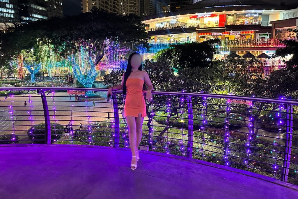 Beautiful Pinay woman standing in Cebu shopping mall during Christmas season, with beautiful Christmas lights.