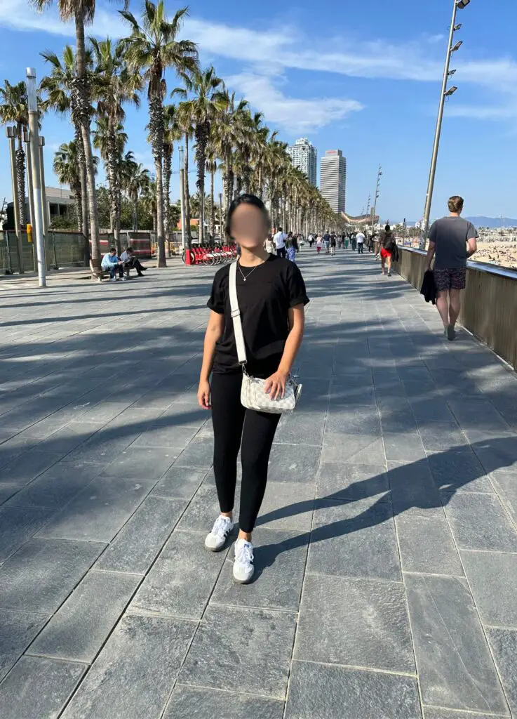 Beautiful Spanish woman standing in Barcelona near the beach strip. A good place for PUA daygame.