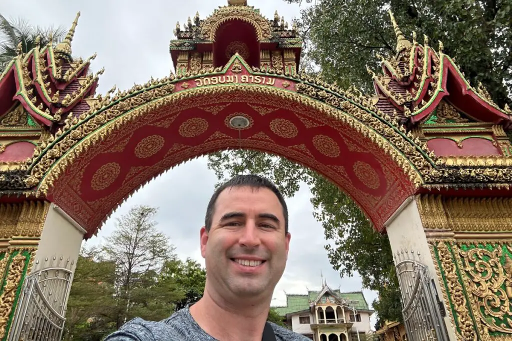 American taking a selfie of a Buddhist temple in Vientiane, Laos.